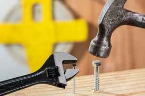 hammering a nail into wood, yellow background